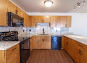 Thumbnail 1 of 9 - A kitchen with wooden cabinets and a marble countertop.