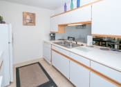 Thumbnail 5 of 12 - a kitchen with white cabinets and a sink and a refrigerator