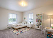 Thumbnail 6 of 11 - A bedroom with a bed, nightstand, and bookshelf.