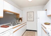 Thumbnail 4 of 11 - A kitchen with white cabinets and a fridge.