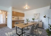 Thumbnail 2 of 11 - A dining room with a wooden table and grey chairs.
