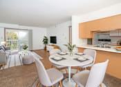 Thumbnail 2 of 17 - A modern dining room with a white table and chairs.