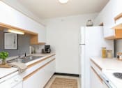 Thumbnail 3 of 10 - A kitchen with white cabinets and a white fridge.
