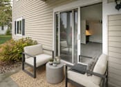 Thumbnail 8 of 10 - A patio with a chair and a table with candles on it.