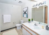 Thumbnail 10 of 14 - A white towel hangs on a towel rack in a bathroom.