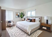 Thumbnail 9 of 14 - A bedroom with a large bed and a wooden nightstand.