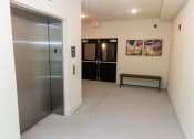 Thumbnail 34 of 35 - a hallway with a stainless steel elevator and a bench