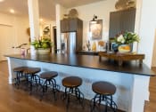 Thumbnail 25 of 35 - a kitchen with a counter top and some bar stools