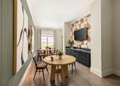 Thumbnail 15 of 31 - A modern dining room with a wooden table and chairs.