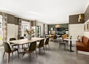 Thumbnail 12 of 31 - A dining room with a table and chairs.