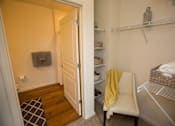 Thumbnail 23 of 32 - A small room with a white chair and a yellow blanket.