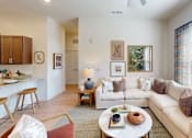 Thumbnail 1 of 25 - A living room with a white couch and a coffee table.