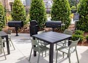 Thumbnail 19 of 25 - A black table surrounded by green chairs.
