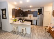 Thumbnail 33 of 40 - a kitchen with a large island and a stainless steel refrigerator