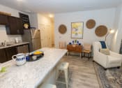 Thumbnail 4 of 40 - Walton Green family affordable community in Augusta, GA a kitchen and living room with a marble counter top