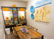 Thumbnail 31 of 40 - a dining area with a wooden table and chairs and a large painting on the wall