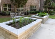 Thumbnail 26 of 40 - a garden with a bench in front of a brick building