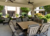 Thumbnail 29 of 40 - a covered patio with a table and chairs
