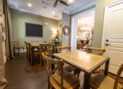 Thumbnail 12 of 40 - a dining room with tables and chairs and a tv on the wall