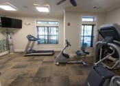 Thumbnail 21 of 40 - a gym with treadmills and elliptical machines