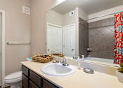 Thumbnail 10 of 14 - A bathroom with a white sink and a mirror.