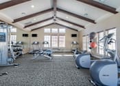 Thumbnail 11 of 14 - A gym with a variety of equipment including treadmills, weights, and exercise balls.