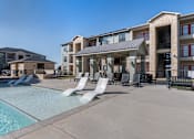 Thumbnail 3 of 14 - A large swimming pool in front of apartment buildings.
