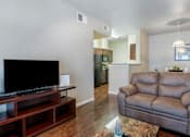 Thumbnail 5 of 14 - A living room with a grey couch and a black television.