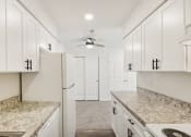 Thumbnail 7 of 37 - view of kitchen with white cabinets and granite counter tops and white appliances at Brookwood at Ridge, New York, 11961