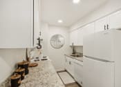 Thumbnail 10 of 37 - a beautiful white kitchen with white cabinets and a white refrigerator at Brookwood at Ridge, New York, 11961