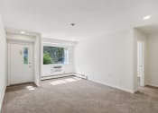 Thumbnail 9 of 37 - a view of living room with white walls and a window, front door and bedroom entrance at Brookwood at Ridge, New York, 11961