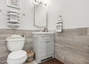 Thumbnail 14 of 37 - a white bathroom with a toilet and a sink at Brookwood at Ridge, New York, 11961