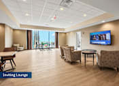 Thumbnail 22 of 31 - A spacious lounge area with a flat screen TV mounted on the wall.