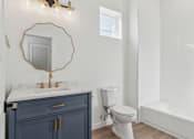 Thumbnail 46 of 48 - A bathroom with a toilet, sink, and a mirror.
