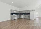 Thumbnail 4 of 48 - A kitchen with white cabinets and a wooden floor.