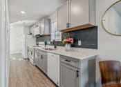 Thumbnail 5 of 48 - A kitchen with white cabinets and a wooden chair.