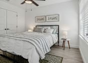 Thumbnail 13 of 48 - A bedroom with a bed, a ceiling fan, and two lamps.