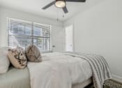 Thumbnail 6 of 48 - A bedroom with a bed, pillows, and a ceiling fan.