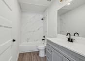 Thumbnail 14 of 48 - A white bathroom with a marble wall and a toilet.