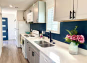 Thumbnail 42 of 48 - a kitchen with white cabinets and a sink and a window