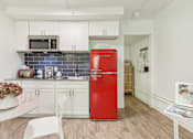 Thumbnail 8 of 38 - a kitchen with white cabinets and a red refrigerator