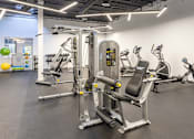 Thumbnail 19 of 38 - a gym with cardio machines and weights at the district at highland village apartments