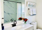 Thumbnail 8 of 48 - a bathroom with a sink and a mirror and a toilet