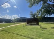 Thumbnail 47 of 48 - a building with a sign in front of a grass field