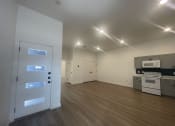 Thumbnail 23 of 48 - an empty living room with a door to a kitchen