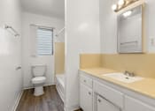 Thumbnail 5 of 17 - A white toilet sits in a bathroom next to a sink.