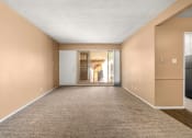 Thumbnail 2 of 23 - a living room with a carpeted floor and a door to a hallway