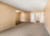 Thumbnail 3 of 23 - an empty living room with carpet and a door to a hallway
