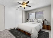 Thumbnail 4 of 17 - A bedroom with a bed, a ceiling fan, and a window.