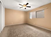 Thumbnail 6 of 23 - an empty bedroom with a ceiling fan and a window